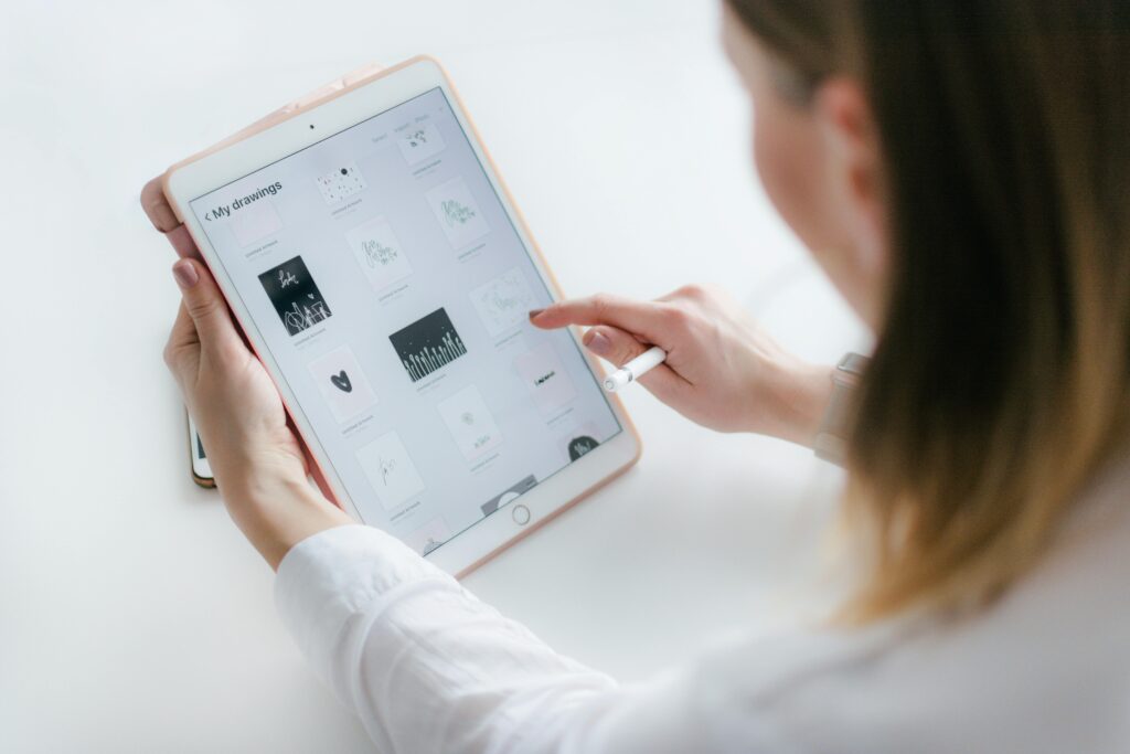 A woman interacts with a tablet to create digital art. Ideal for technology and creativity concepts.